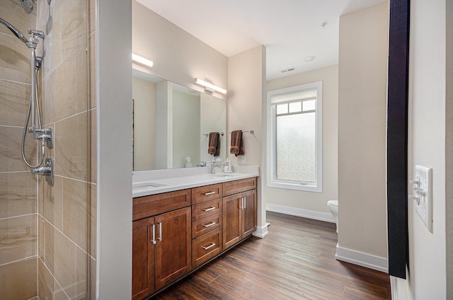 441 S Ashley Unit 306, Ann Arbor, MI 48103 - full bath featuring a sink, double vanity, toilet, baseboards, and wood finished floors