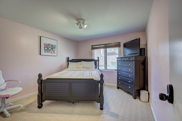 bedroom featuring baseboards and light colored carpet