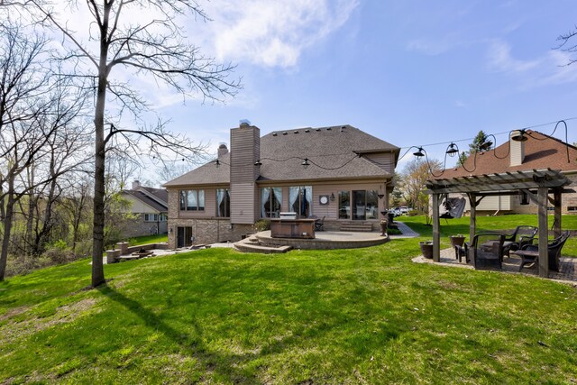 back of house with a chimney, a patio, an outdoor fire pit, a yard, and a pergola