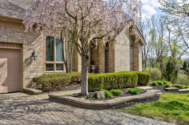 view of side of property with brick siding and an attached garage