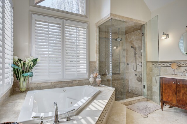 full bath with vanity, a stall shower, and a tub with jets