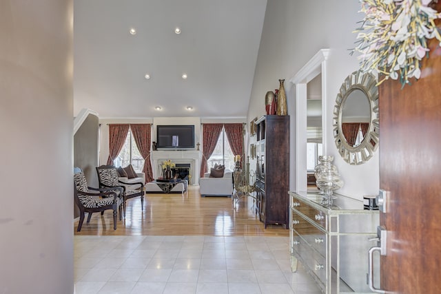 entrance foyer with a fireplace, tile patterned floors, a wealth of natural light, and high vaulted ceiling