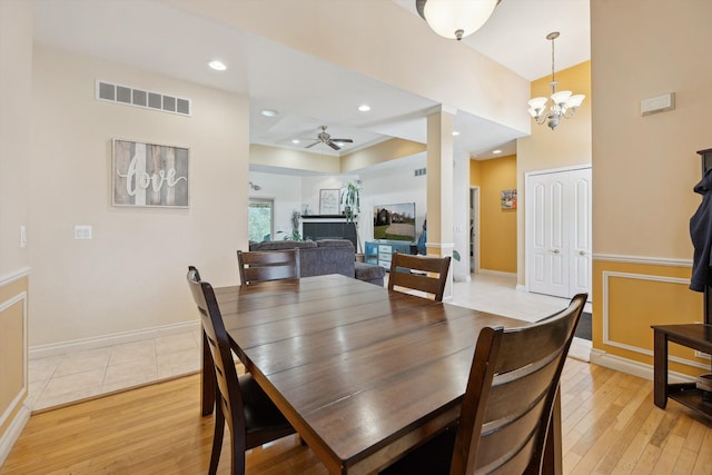 11613 Butler Rd, Willis, MI 48191 - dining room with baseboards, light wood finished floors, visible vents, and ceiling fan with notable chandelier