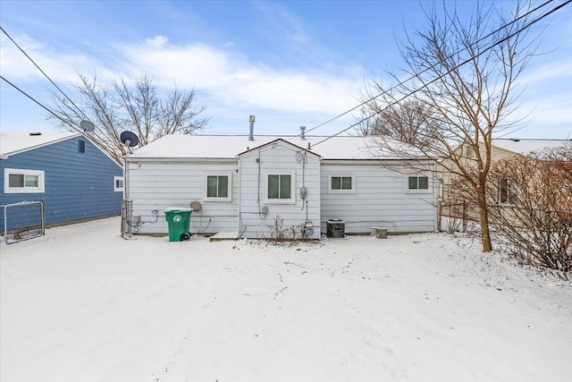 snow covered property featuring fence and central air condition unit