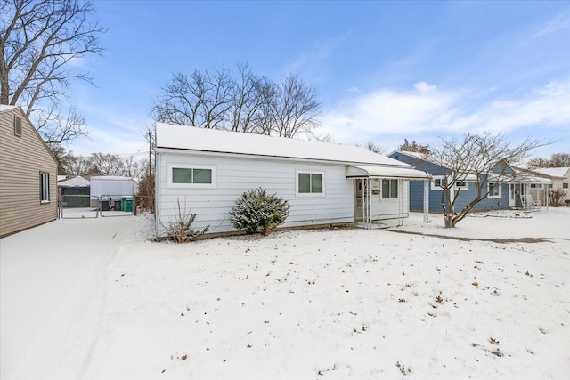 snow covered property featuring a gate and fence