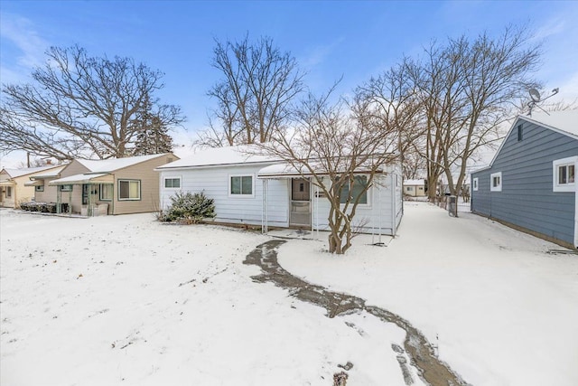 view of snow covered rear of property