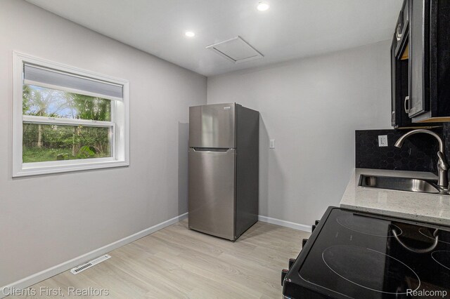 26358 Moses St, Flat Rock, MI 48134 - kitchen with freestanding refrigerator, black / electric stove, a sink, light wood-style flooring, and baseboards