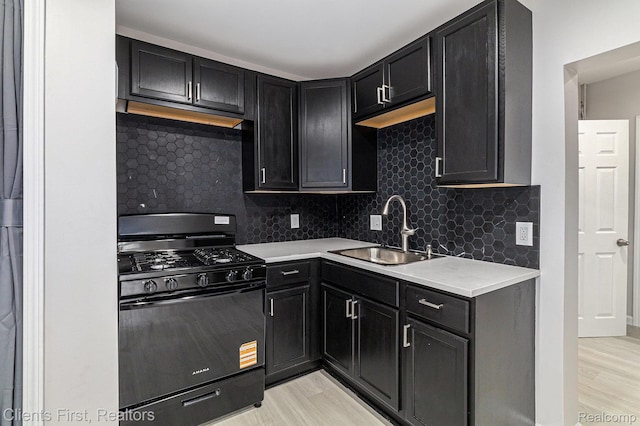 26358 Moses St, Flat Rock, MI 48134 - kitchen with black gas stove, a sink, light wood-style flooring, and backsplash