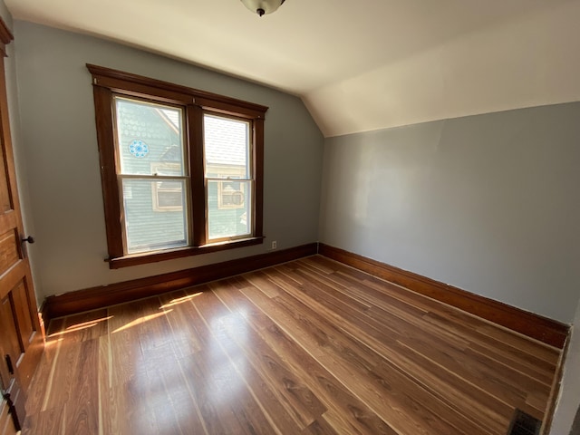 617 Forest St, Kalamazoo, MI 49008 - additional living space with lofted ceiling, visible vents, dark wood-style floors, and baseboards
