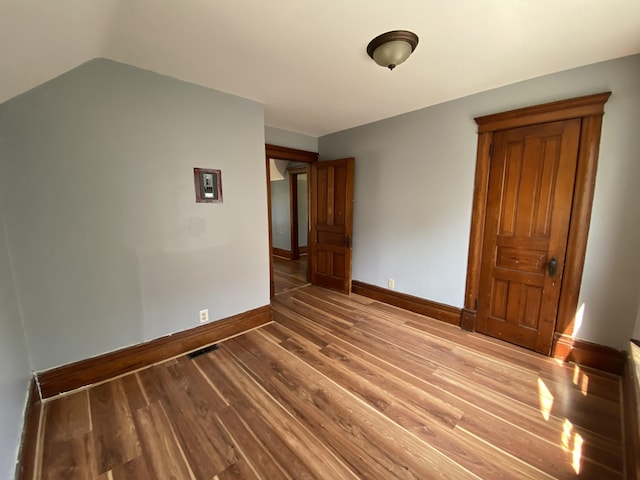 617 Forest St, Kalamazoo, MI 49008 - unfurnished room featuring baseboards, lofted ceiling, wood finished floors, and visible vents