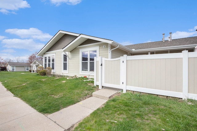 view of front of house with a gate, a front lawn, and fence