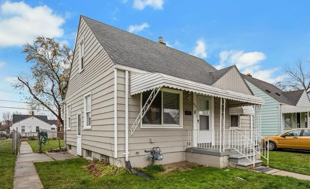 bungalow-style home with a front yard, fence, a shingled roof, and a gate