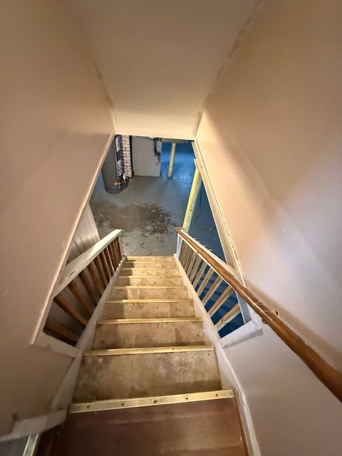 staircase featuring unfinished concrete floors