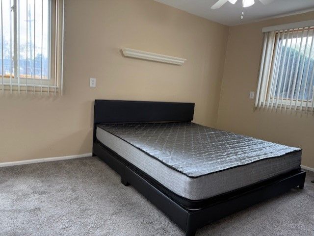 carpeted bedroom with a ceiling fan and baseboards