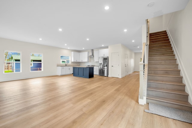 unfurnished living room with light wood-style floors, stairs, and recessed lighting