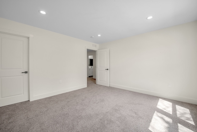 carpeted spare room featuring visible vents, recessed lighting, and baseboards