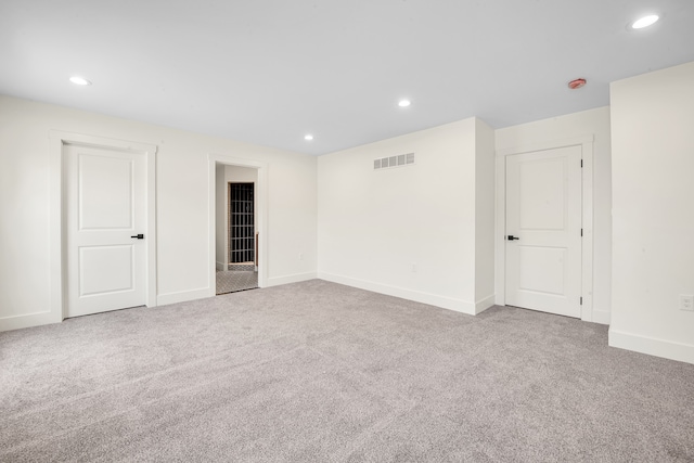carpeted empty room with recessed lighting, visible vents, and baseboards