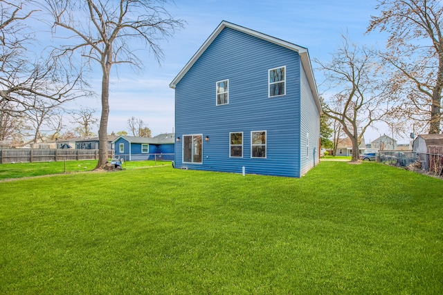 back of house with a lawn and a fenced backyard