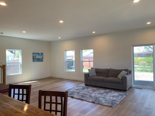 living room with recessed lighting, wood finished floors, and plenty of natural light