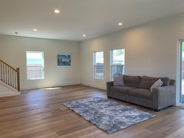 living room featuring recessed lighting, stairway, wood finished floors, and baseboards