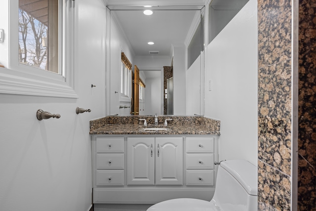 bathroom with visible vents, vanity, toilet, ornamental molding, and recessed lighting