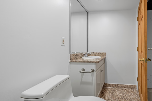 bathroom featuring vanity, baseboards, toilet, and tile patterned flooring