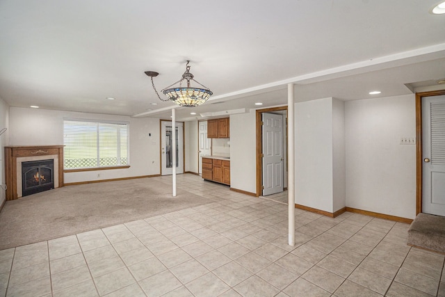 unfurnished living room featuring recessed lighting, baseboards, a lit fireplace, and light tile patterned flooring