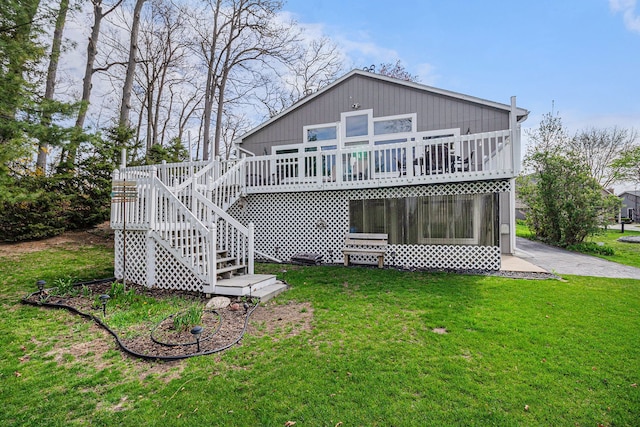 back of property with a lawn, a deck, and stairs
