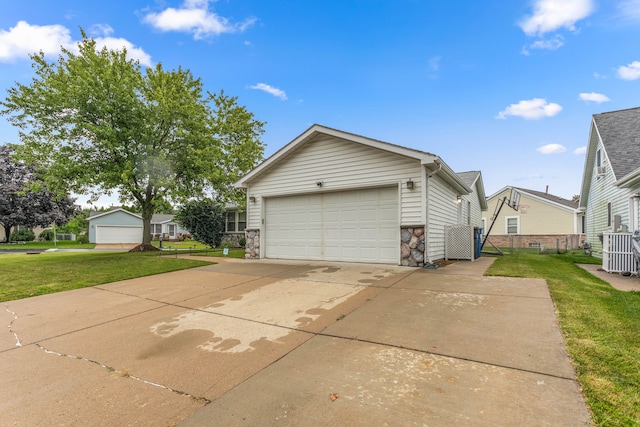 exterior space featuring stone siding, concrete driveway, fence, an attached garage, and a yard