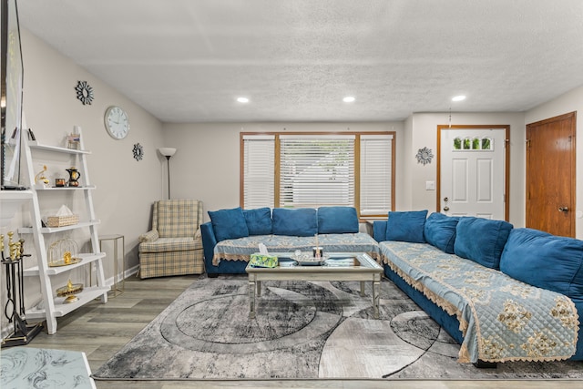 living room featuring baseboards, wood finished floors, recessed lighting, and a textured ceiling