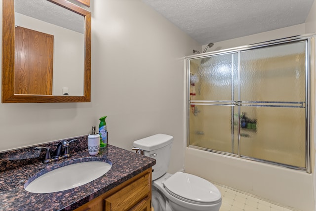 bathroom featuring enclosed tub / shower combo, a textured ceiling, vanity, and toilet
