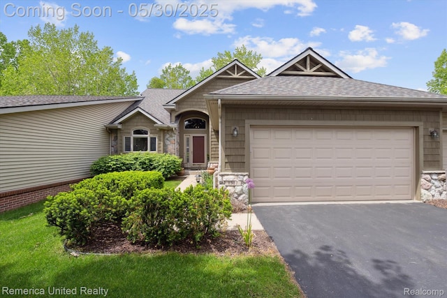 1317 Peppergrove Dr, Brighton, MI 48116 - view of front of home featuring a shingled roof, stone siding, driveway, and an attached garage