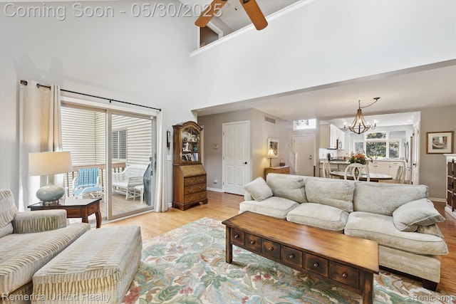 1317 Peppergrove Dr, Brighton, MI 48116 - living area with light wood finished floors, baseboards, ceiling fan, a chandelier, and a high ceiling