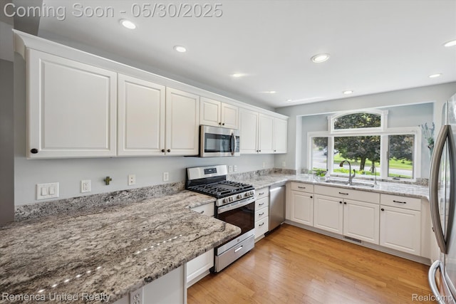 1317 Peppergrove Dr, Brighton, MI 48116 - kitchen with appliances with stainless steel finishes, a sink, white cabinets, recessed lighting, and light stone counters