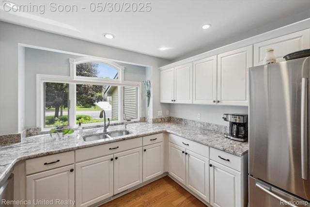 1317 Peppergrove Dr, Brighton, MI 48116 - kitchen featuring freestanding refrigerator, a sink, white cabinetry, recessed lighting, and light wood-type flooring