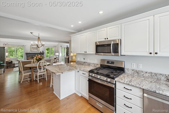 1317 Peppergrove Dr, Brighton, MI 48116 - kitchen with appliances with stainless steel finishes, white cabinets, light wood-type flooring, recessed lighting, and a peninsula