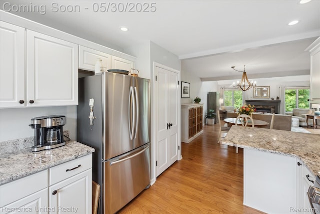 1317 Peppergrove Dr, Brighton, MI 48116 - kitchen featuring freestanding refrigerator, light wood-type flooring, white cabinets, recessed lighting, and open floor plan
