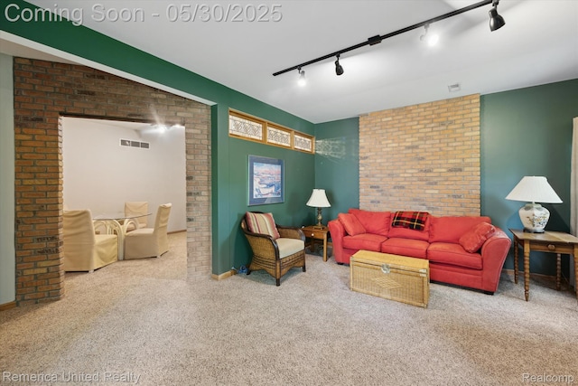 1317 Peppergrove Dr, Brighton, MI 48116 - carpeted living room featuring track lighting, brick wall, and baseboards