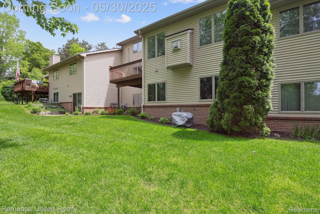 1317 Peppergrove Dr, Brighton, MI 48116 - back of property with brick siding, a chimney, a lawn, and a wooden deck