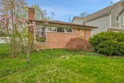 rear view of house featuring a lawn and an attached garage