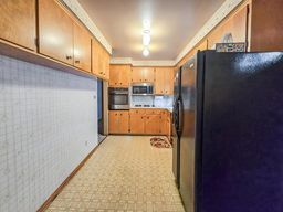 kitchen with freestanding refrigerator, wall oven, and stainless steel microwave