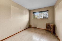 unfurnished room with tile patterned floors and baseboards