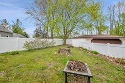 view of yard with a fenced backyard and a fire pit