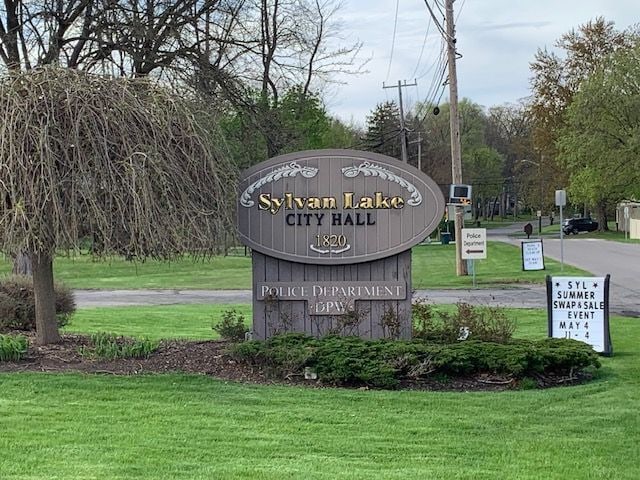 community / neighborhood sign with a yard