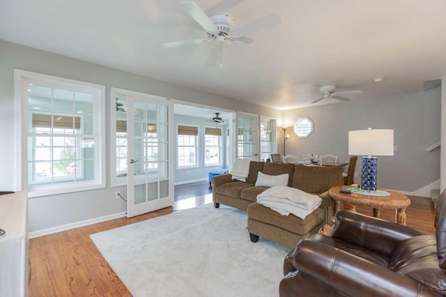 living room featuring a wealth of natural light, ceiling fan, and french doors