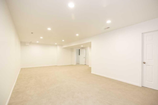 finished below grade area with baseboards, light carpet, and recessed lighting