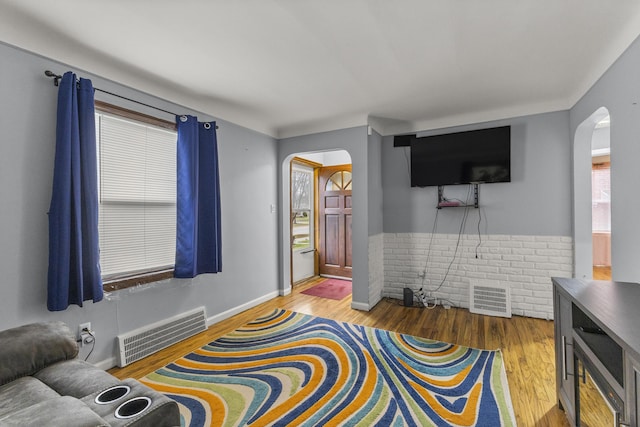 8450 Warren Blvd, Center Line, MI 48015 - living area featuring arched walkways, wood finished floors, visible vents, and baseboards