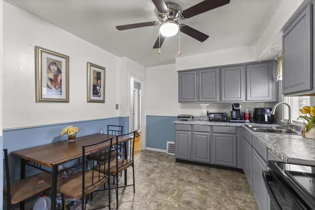 8450 Warren Blvd, Center Line, MI 48015 - kitchen featuring tasteful backsplash, a sink, electric range, gray cabinetry, and visible vents