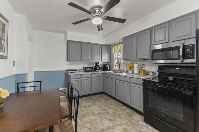 8450 Warren Blvd, Center Line, MI 48015 - kitchen with a sink, stainless steel microwave, a ceiling fan, gray cabinetry, and black / electric stove