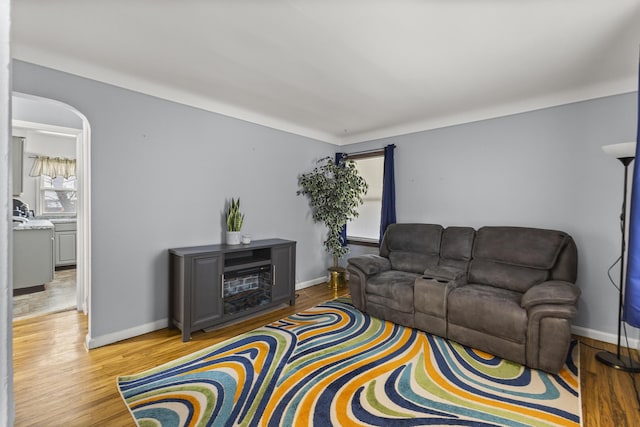 8450 Warren Blvd, Center Line, MI 48015 - living room with arched walkways, light wood-style floors, and baseboards